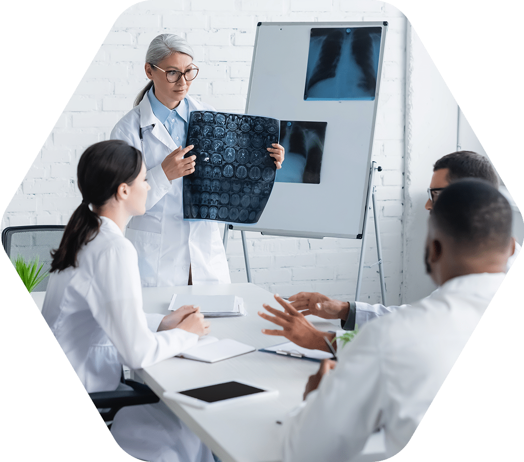 middle aged asian doctor holding head mri scan near multiethnic physicians in meeting room